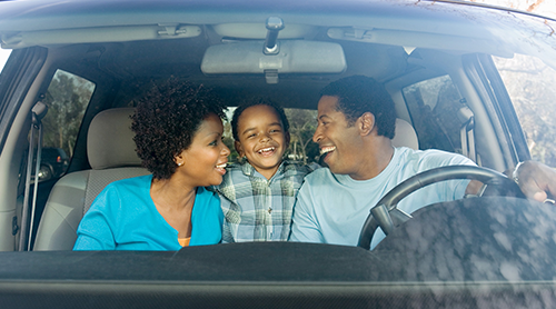 Smilng family of three inside their car - Free Insurance Quotes